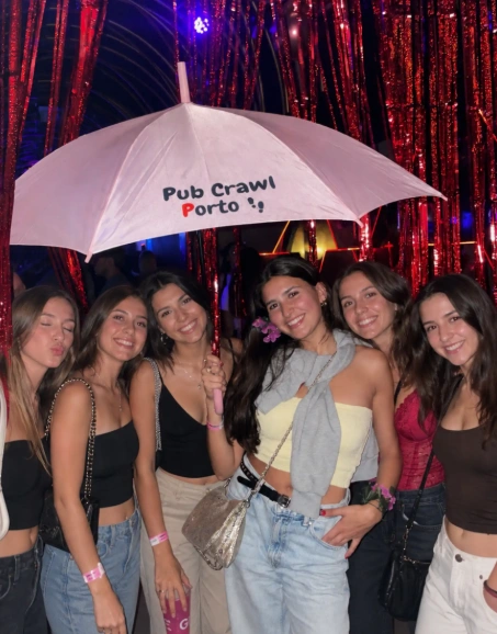 Group of friends posing under the Porto Pub Crawl umbrella